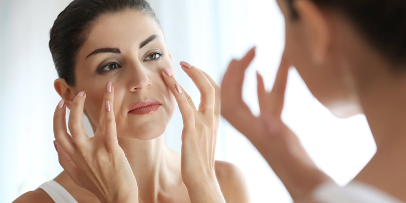 women-checking-face-on-mirror